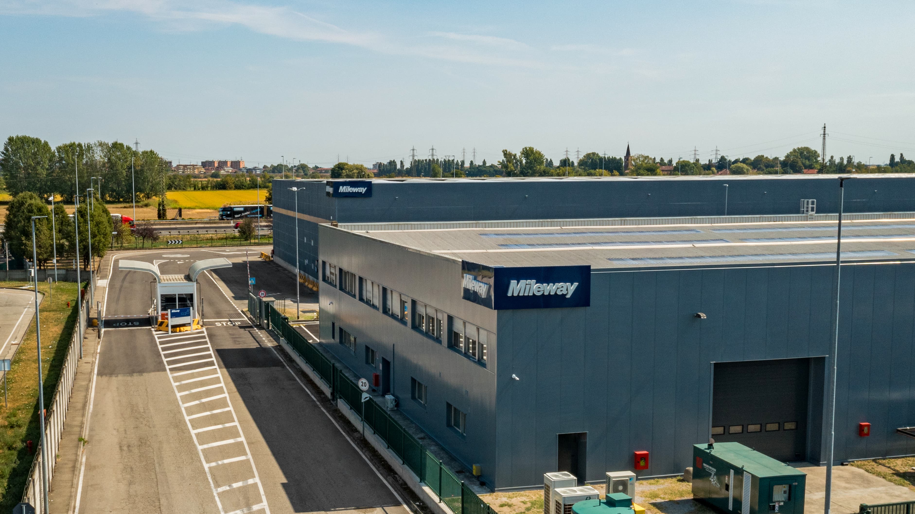 Large industrial building with Mileway signage, located next to a road and surrounded by greenery.