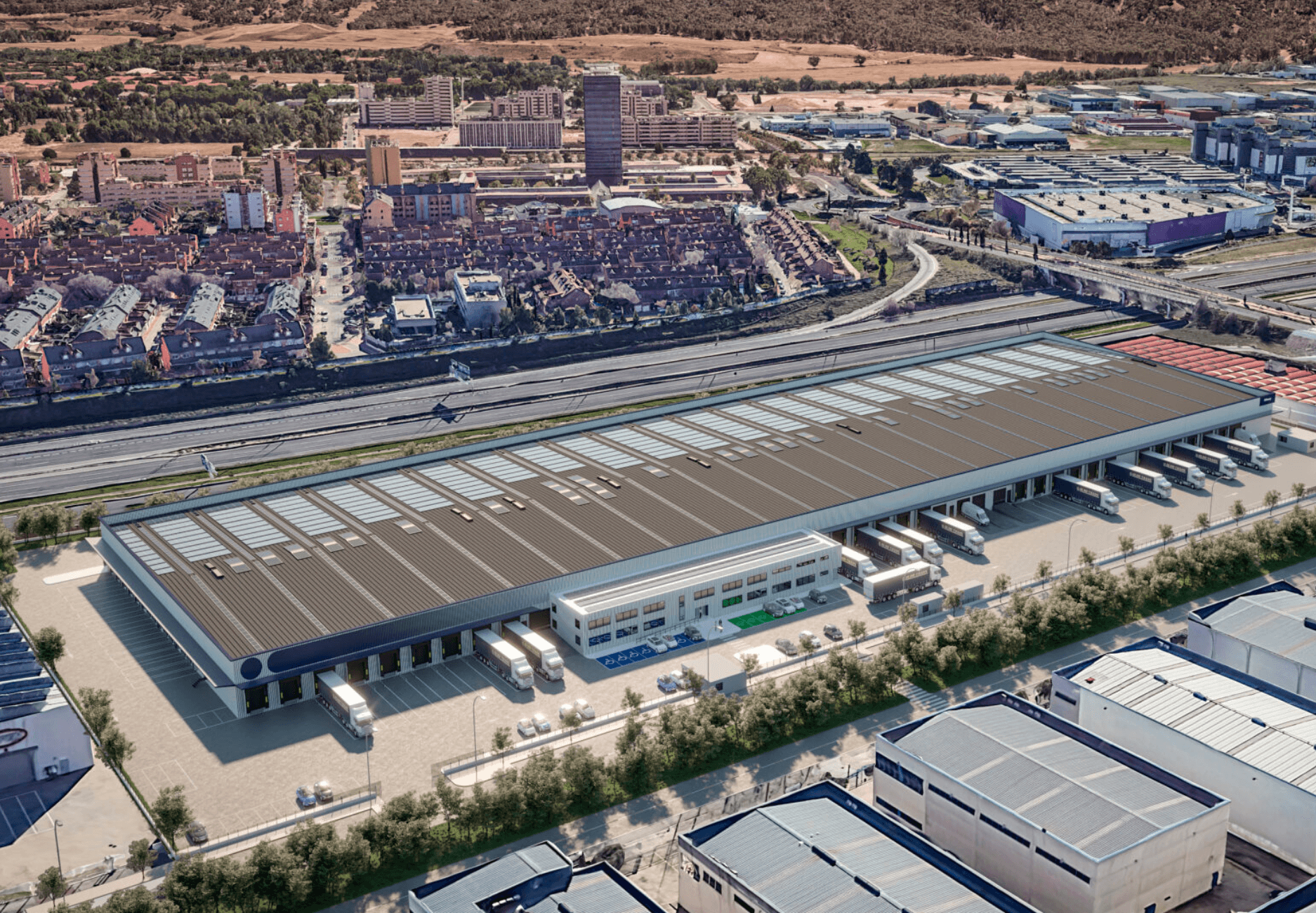 Aerial view of a large logistics warehouse with loading docks and trucks parked outside, situated near a residential area and industrial buildings.